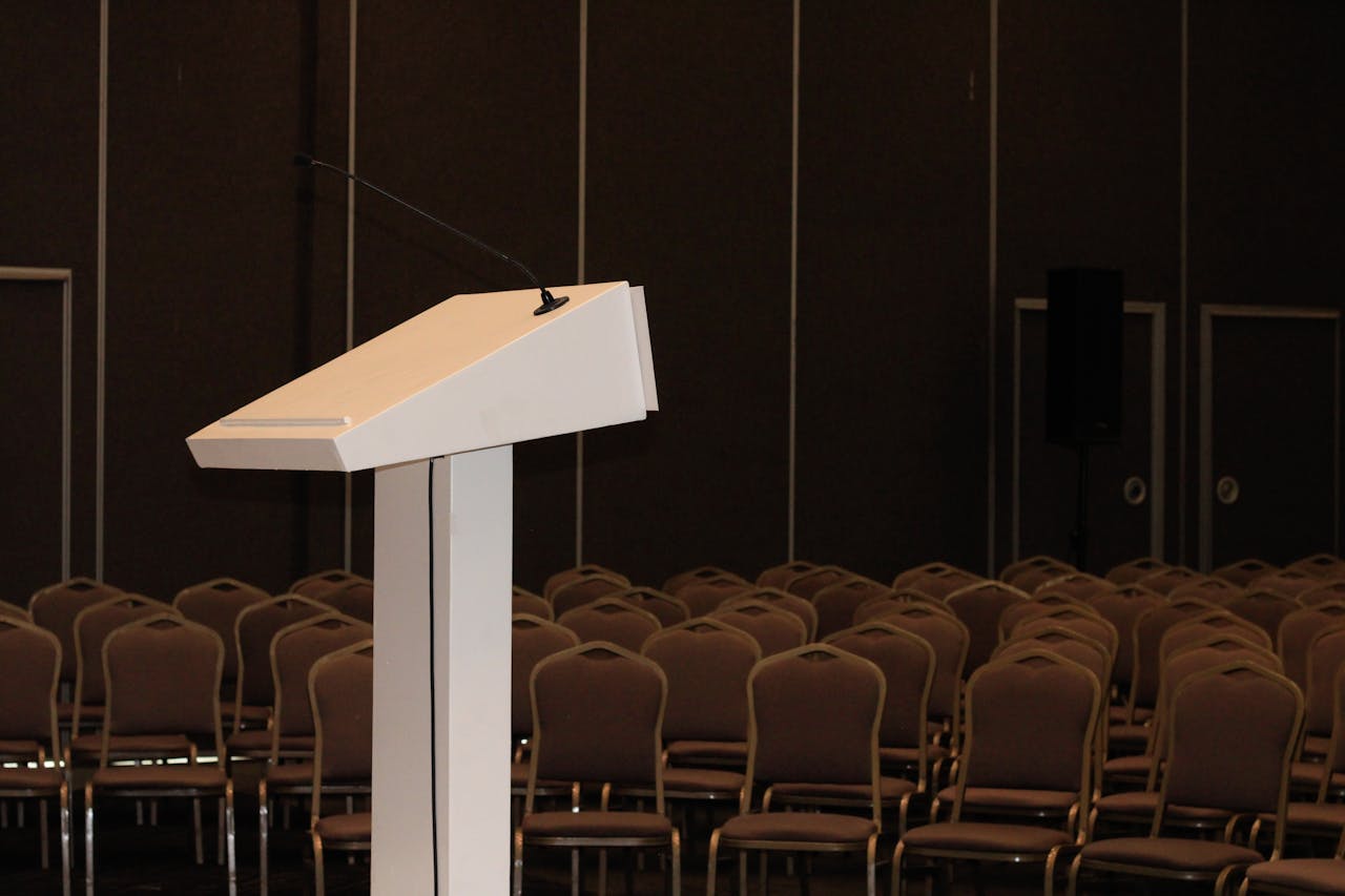 Empty hearing room podium representing the R.C. 3319.16 hearing right for Ohio teachers